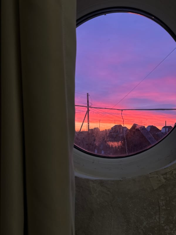 Sunset viewed through circular window in Noviy, Russia