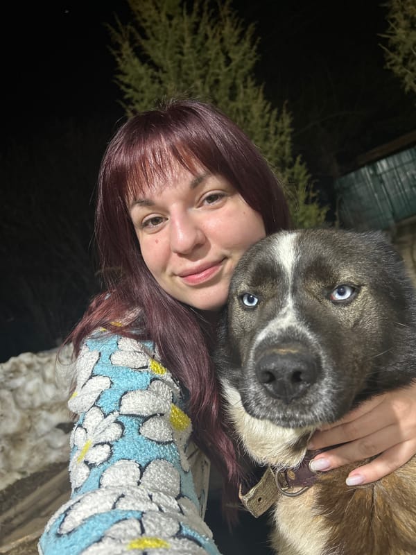 Person poses with blue-eyed dog in Russian home