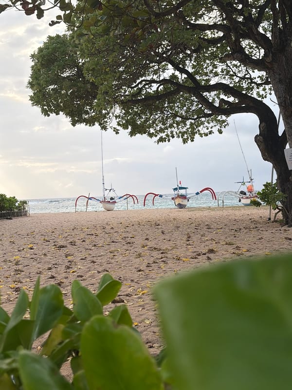 Overcast afternoon on a Kuta Selatan beach, boats and debris included