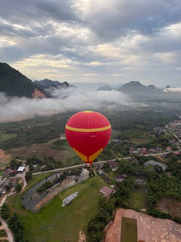 Hot air balloon ride over misty karst mountains near Vang Vieng, Laos