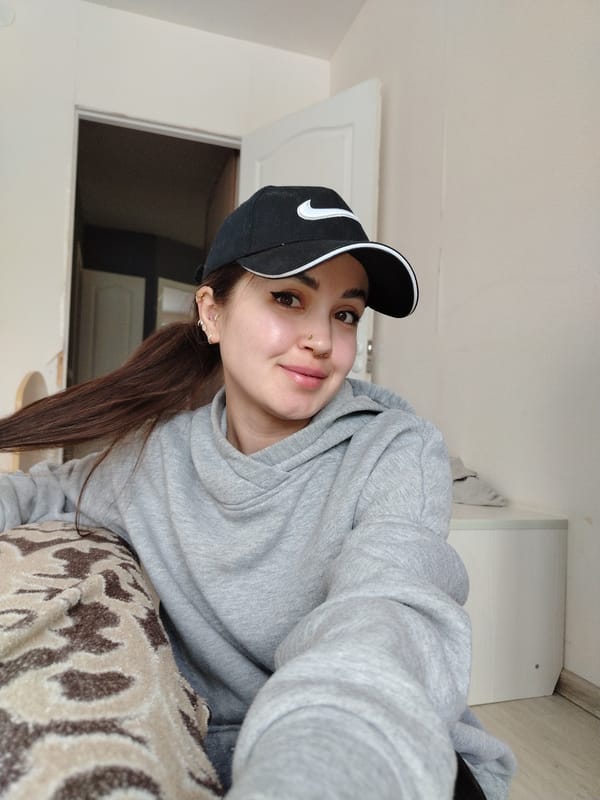 Woman takes selfie wearing Nike cap indoors