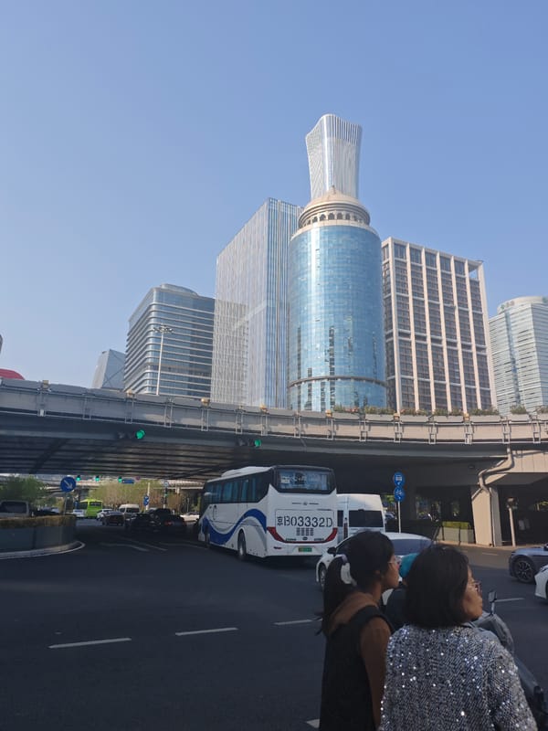 Pedestrians cross busy Chaoyang District intersection on clear Beijing day