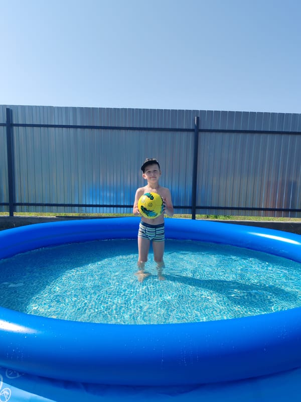 Backyard inflatable pool fun on a summer morning in Chaikovsky