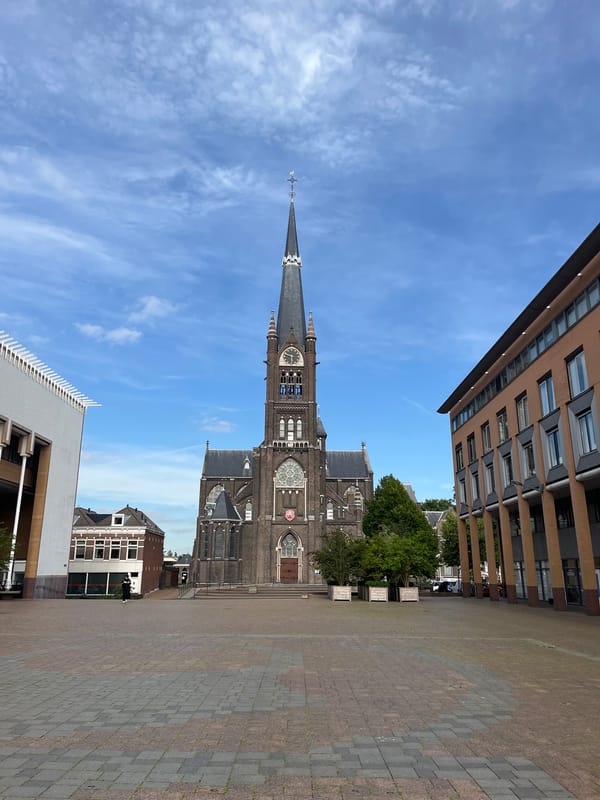 Gothic brick church and Jesus statue in an urban plaza