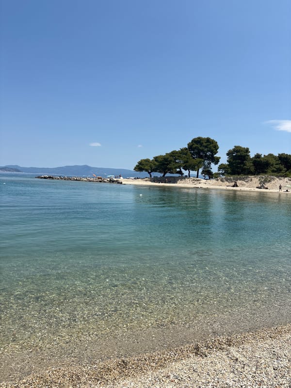 Crystal-clear turquoise water at a Greek pebble beach
