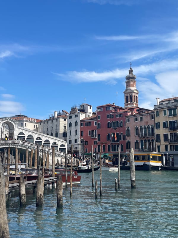 Tourist takes selfies at Venice's Rialto Bridge on sunny day