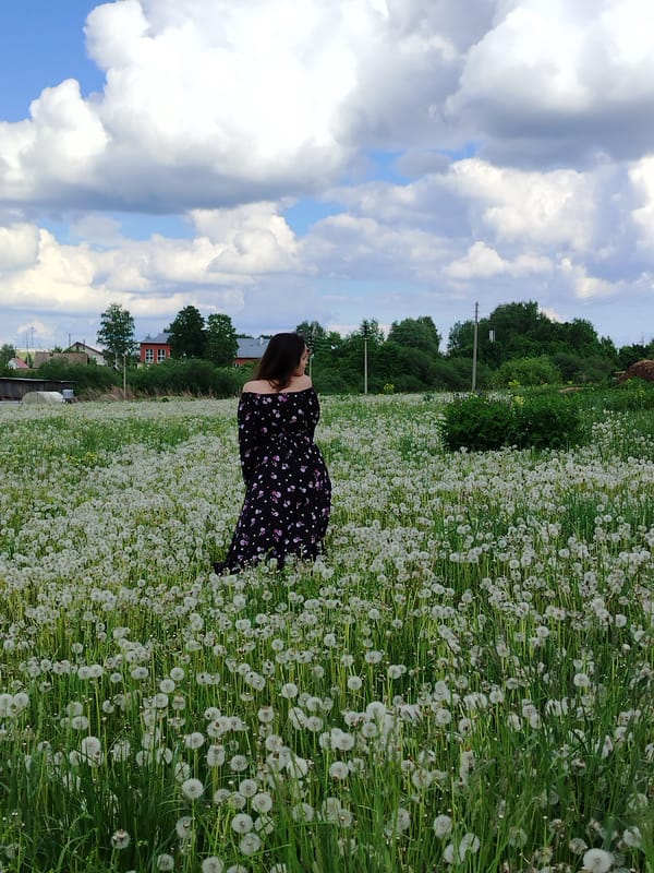Woman poses in dandelion field in rural Russia