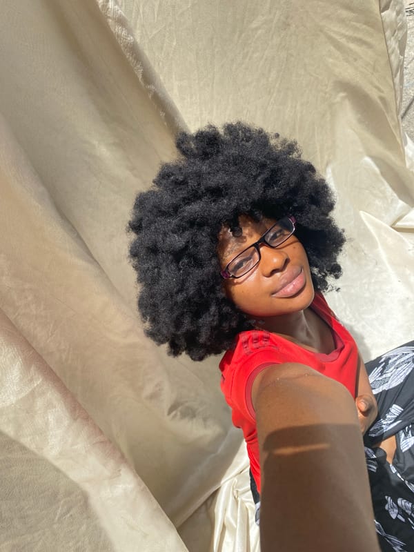 Woman in red shirt resting on fabric surface in Nigeria