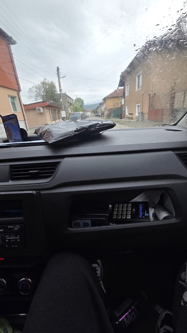 Driver documents rainy rural road journey through windshield