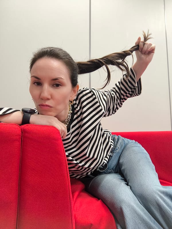 Woman rests on red sofa in striped shirt