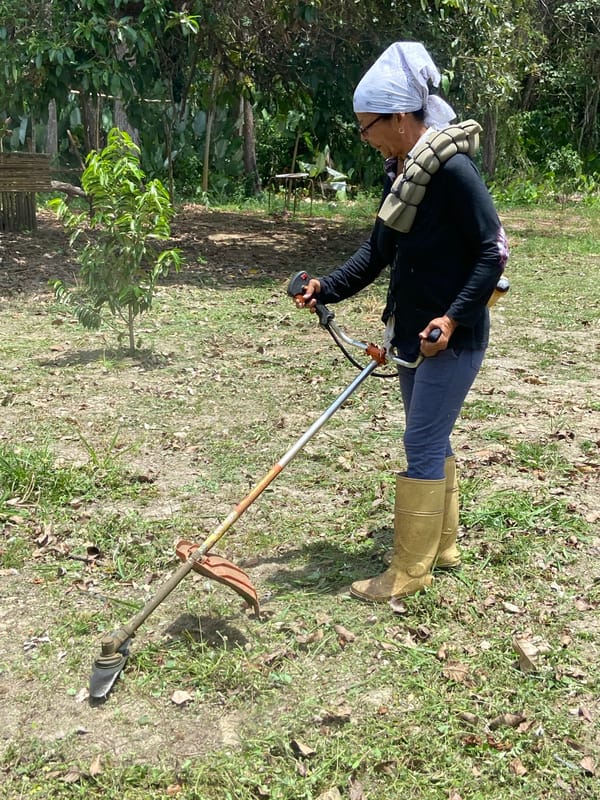 Woman operates string trimmer in Venezuelan field