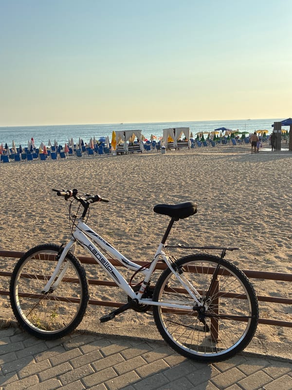White bicycle parked along a sunny Alanya beach promenade