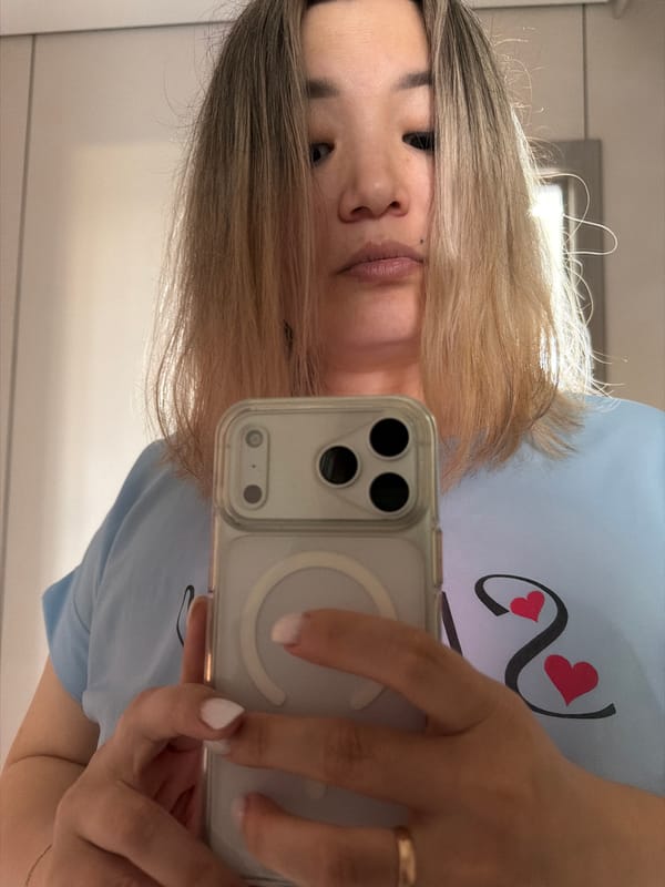 Selfie session in an Astana office, light blue tee, green apples nearby.