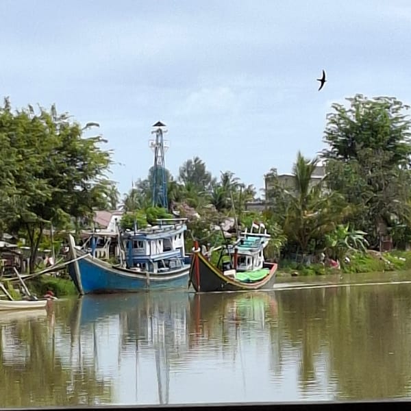 Boats, market stalls, and coffee on a quiet Indonesian morning