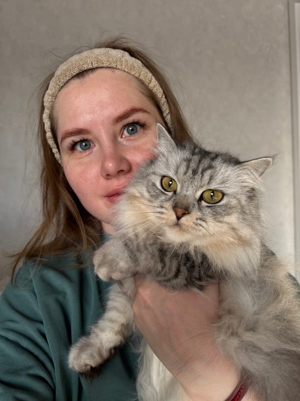 Woman poses with fluffy cat in Russian village