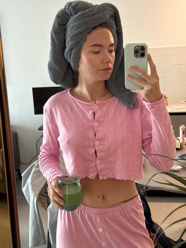 Woman takes mirror selfie with towel, pink outfit in Jordan