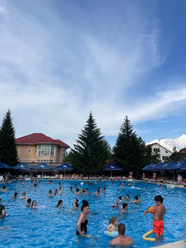 Crowded outdoor pool day at a recreational complex in Almaty