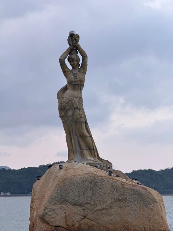 Tourists photograph landmarks at Xiangzhou waterfront during morning visit