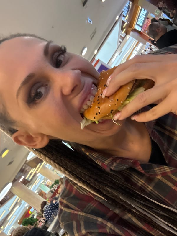 Person eats hamburger at Rusanovo shopping mall