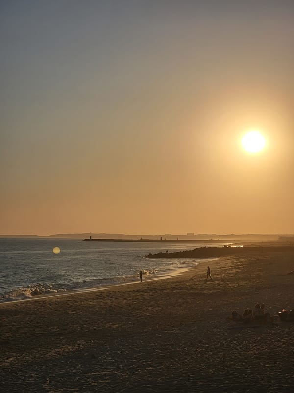 Quarteira beach at golden hour, people and an ambulance nearby