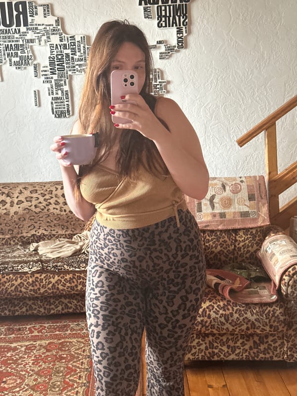 Woman takes mirror selfie with phone and cup in Belarus