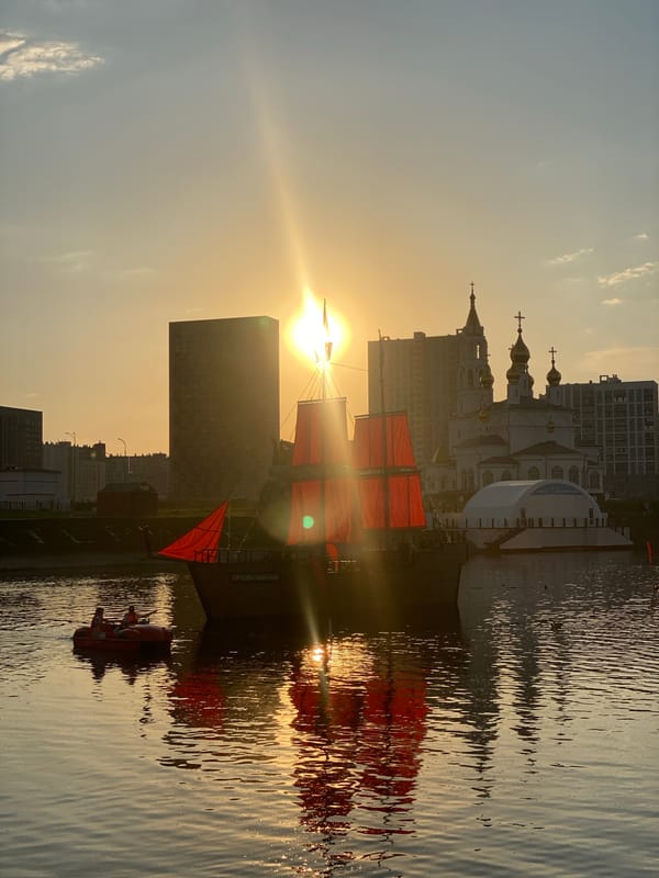 Red-sailed ship captures attention during Yekaterinburg waterfront sunset