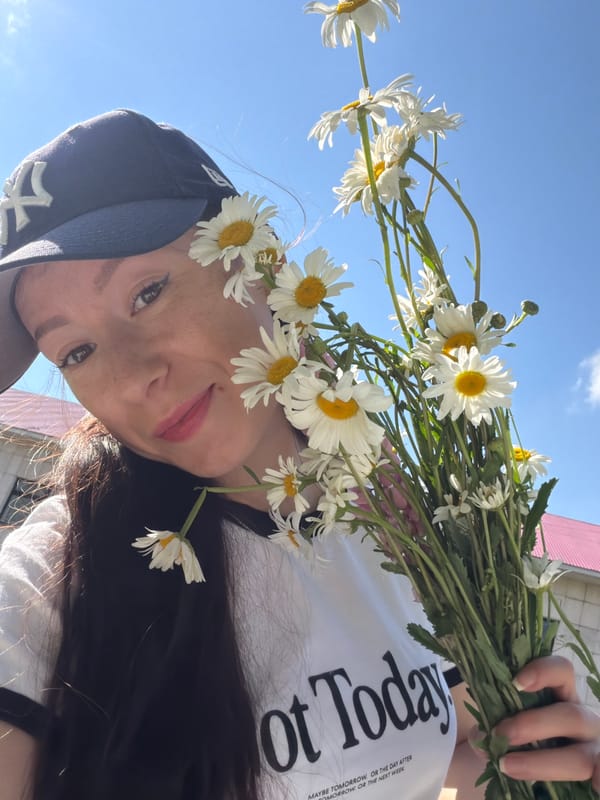 Woman poses with daisy bouquets during outdoor gathering in Tujmazy