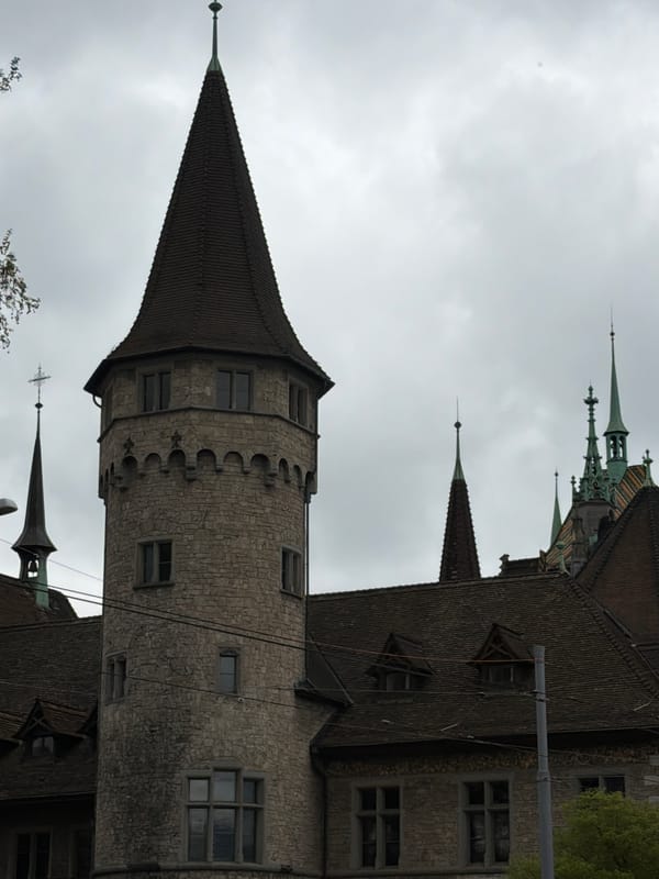 Tourist photographs Zurich's historic Swiss National Museum and Rathaus