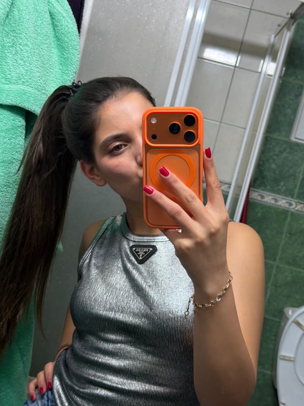 Woman takes bathroom selfie with orange iPhone in Bulgaria