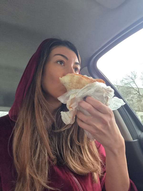 Woman eats shawarma sandwich in car in Plovdiv