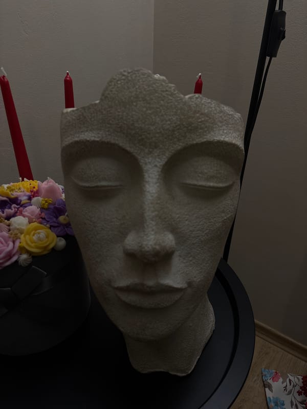 White sculptural face displayed with flowers in Veliko Tarnovo