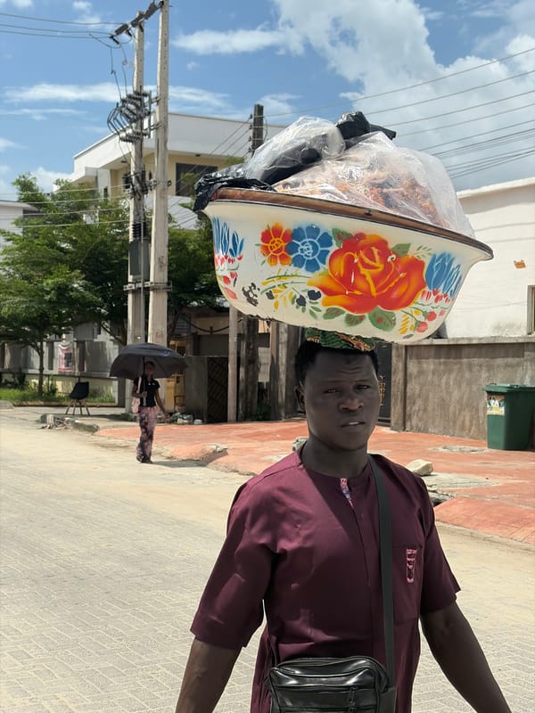 Man carries food bowl on head in Igboefon street