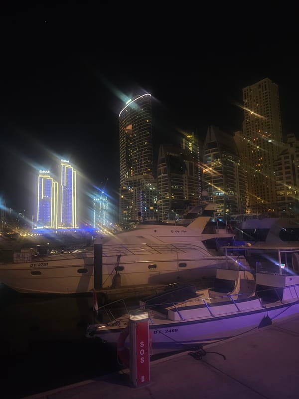 Dubai marina nighttime scene captured with docked yachts, illuminated towers