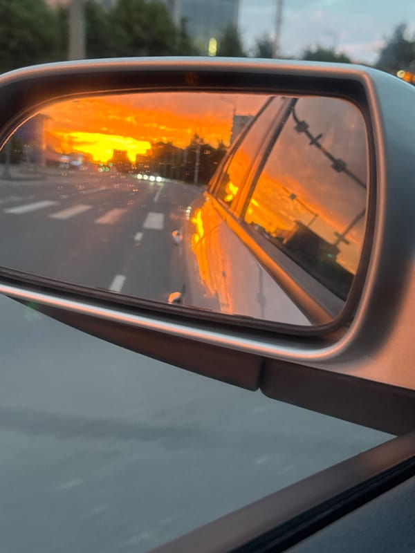 Tallinn sunset burns across streets, rooftops, and rearview mirrors