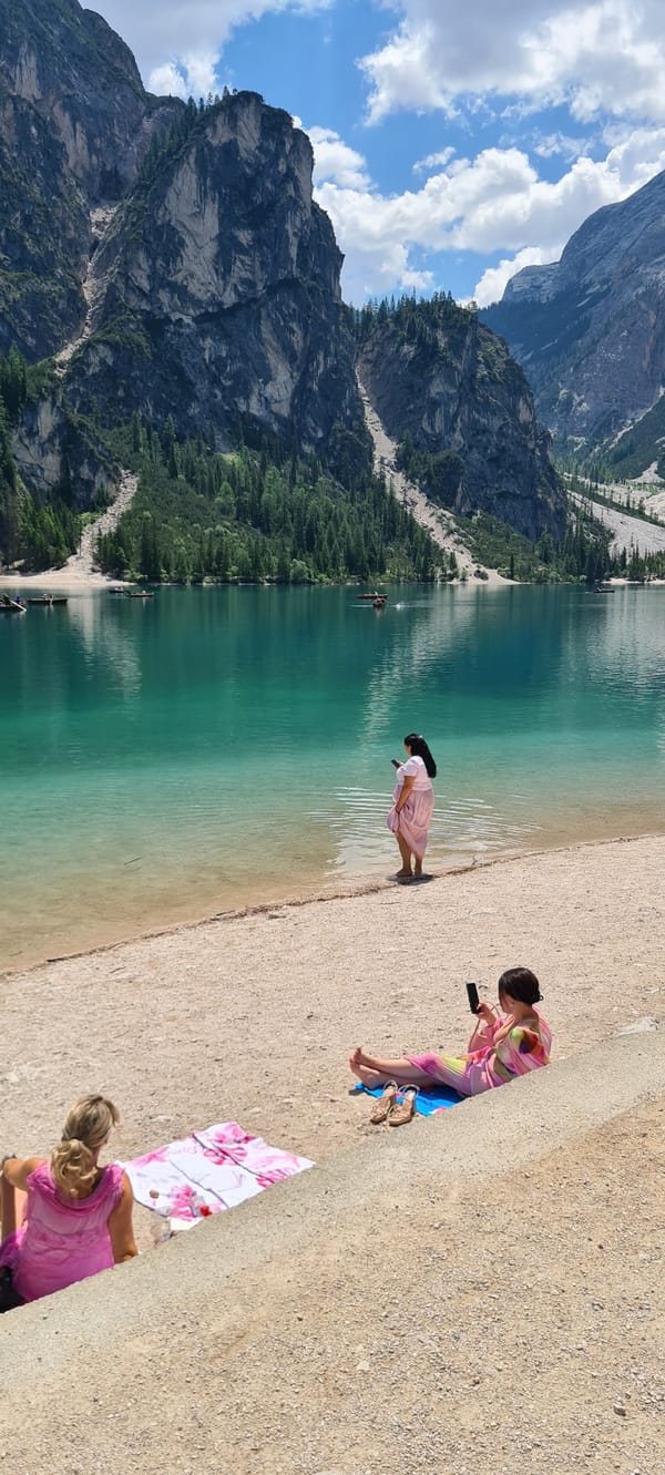 Morning at Lago di Braies, Dolomites — lake, peaks, and a dog