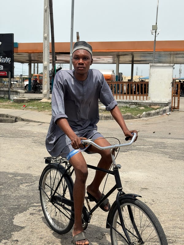 Man in traditional dress cycles through Igboefon, Nigeria