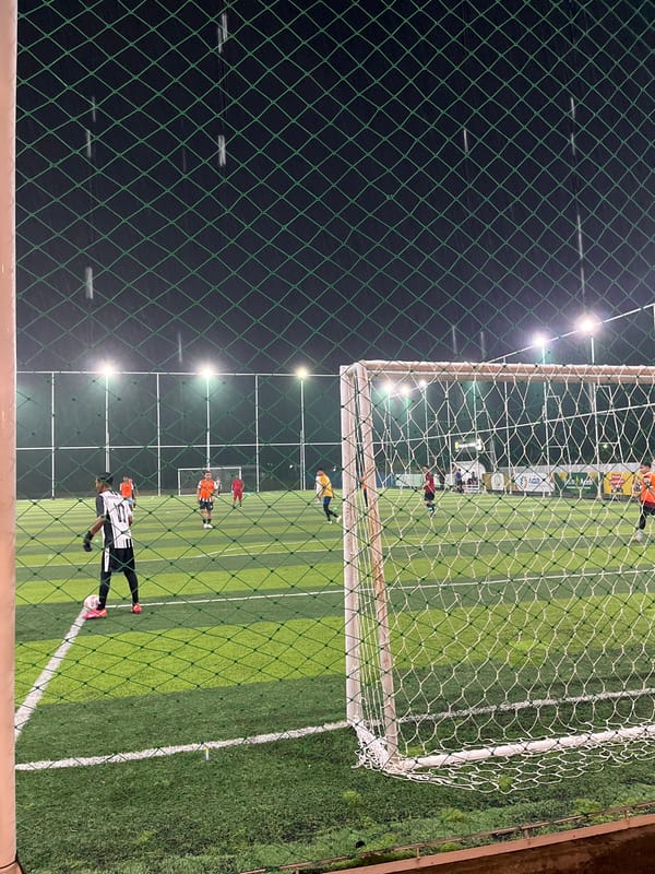 Evening soccer match and commercial activity documented in Lhokseumawe