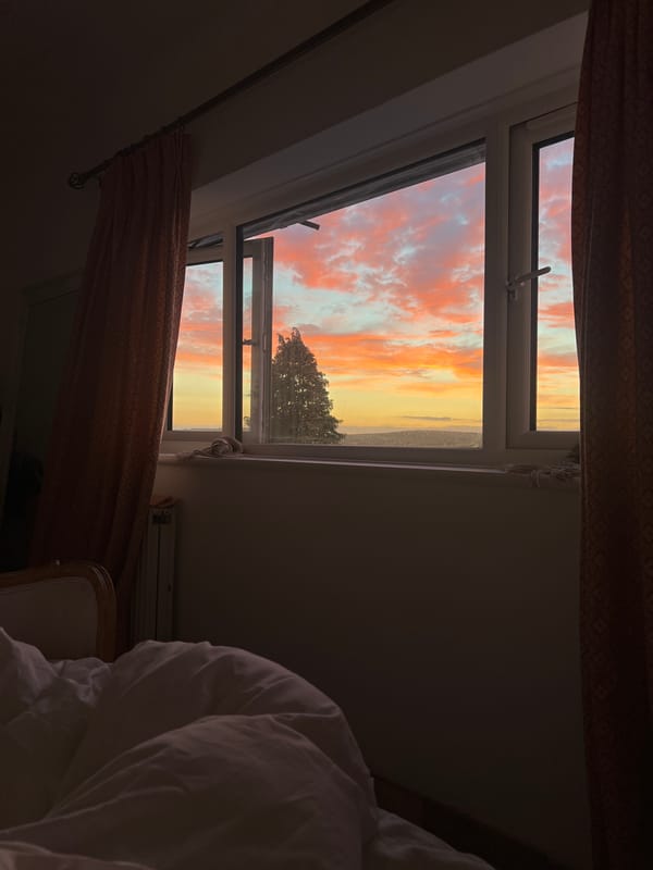 Brighton sunset viewed through a bedroom window at dusk