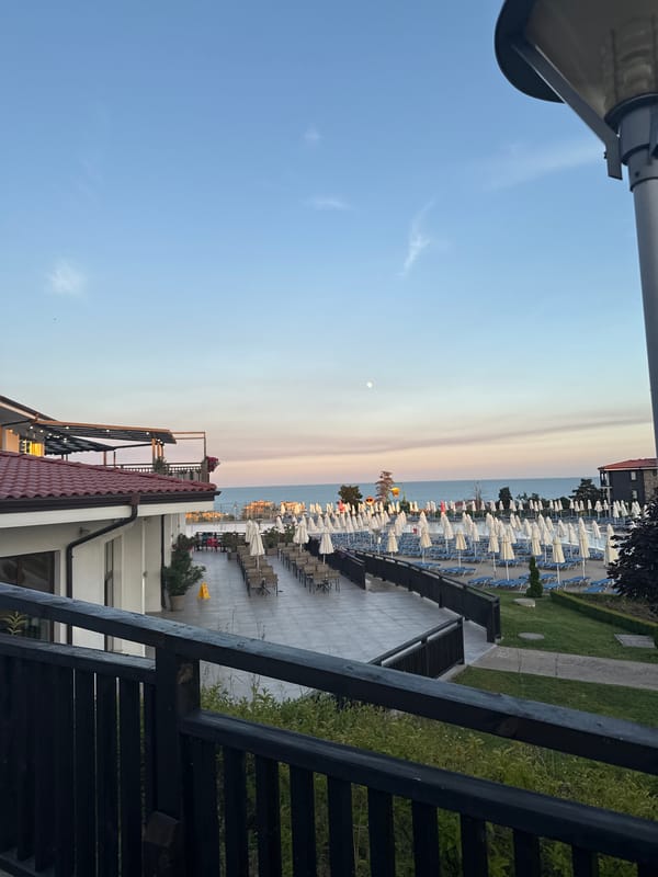 Resort terrace at dusk, framed by a wooden railing