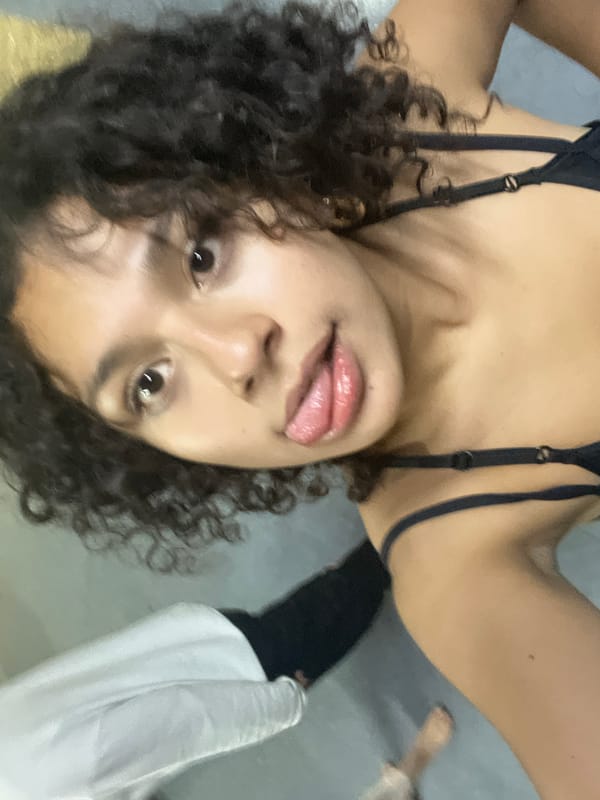 Person photographed upside down with tongue out, second individual partially visible