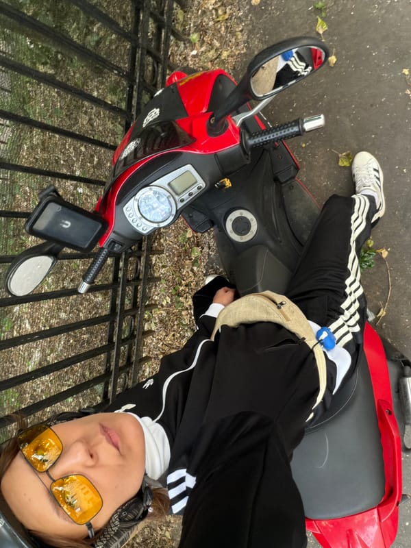 Relaxing on a red scooter in a sharp matching tracksuit