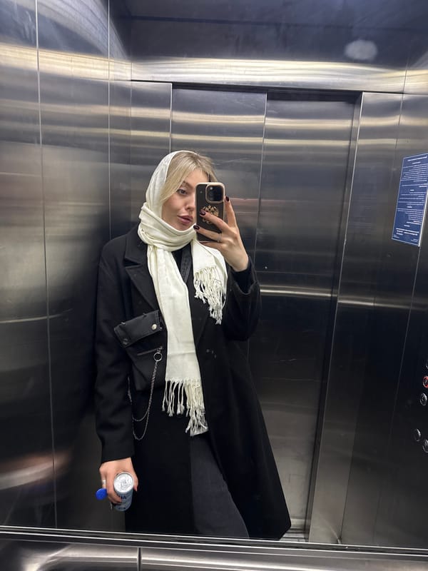 Woman with beverage observed in mirrored elevator in Krasnoyarsk