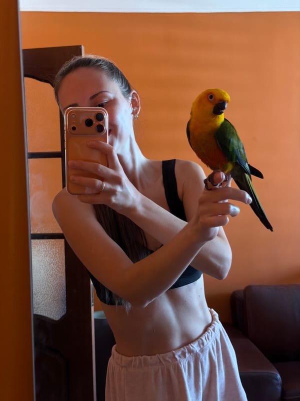 Woman takes selfie with sun conure parrot in Khimki