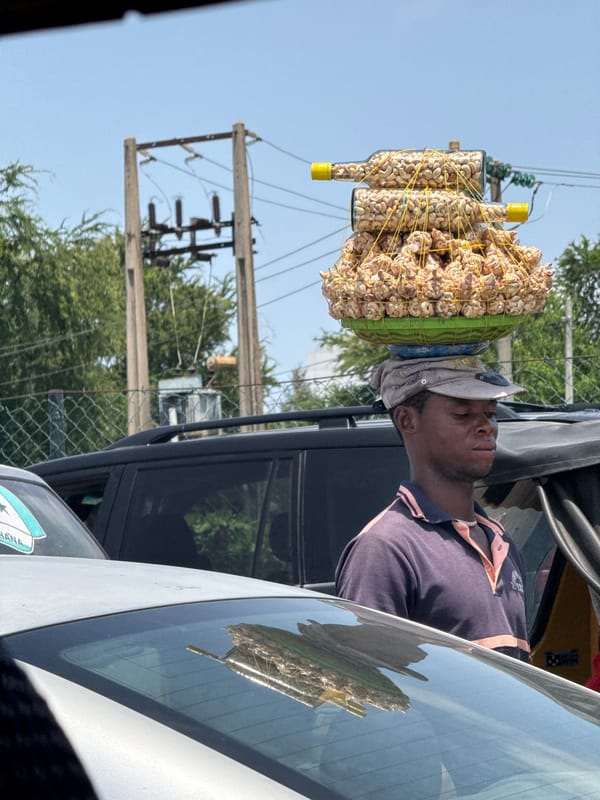 Street vendor carries goods in basket through Lekki, Nigeria