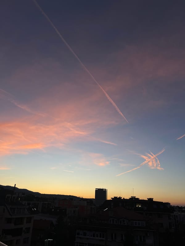 Evening contrails streak across sunset sky in Sofia
