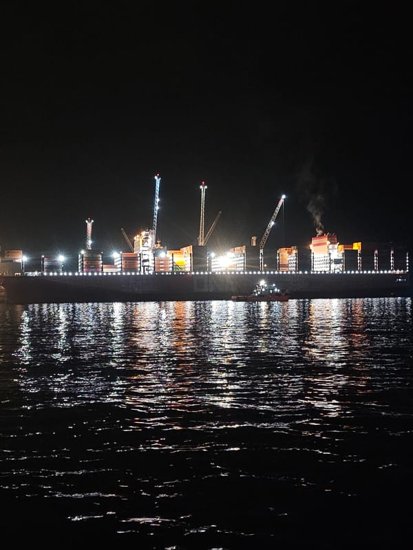 Late-night waterfront hangout with a cargo ship backdrop in Iquique