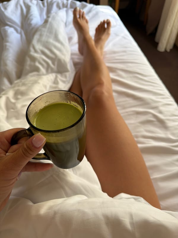 Person holds green beverage in bed, Svetlogorsk morning