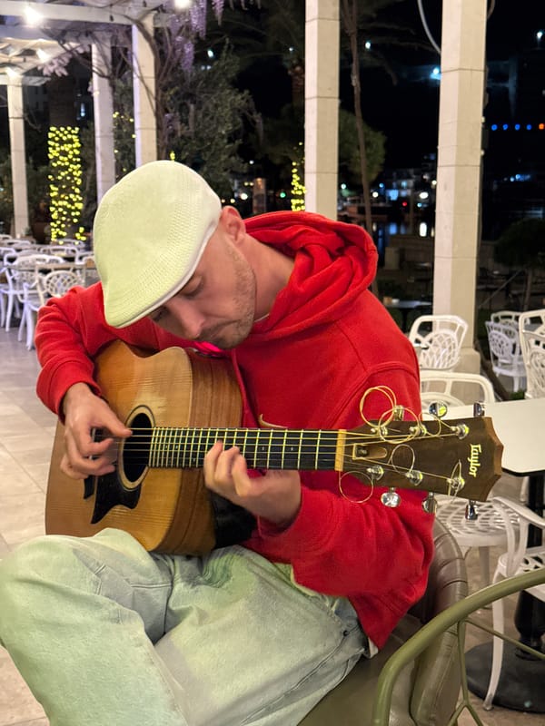 Street musician plays acoustic guitar outdoors in Montenegro
