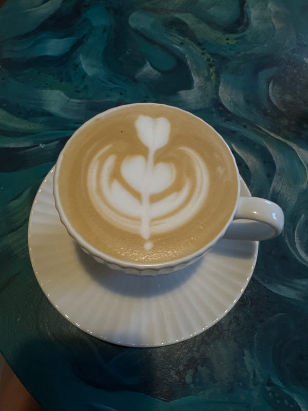 Woman enjoys coffee with latte art at Minsk cafe