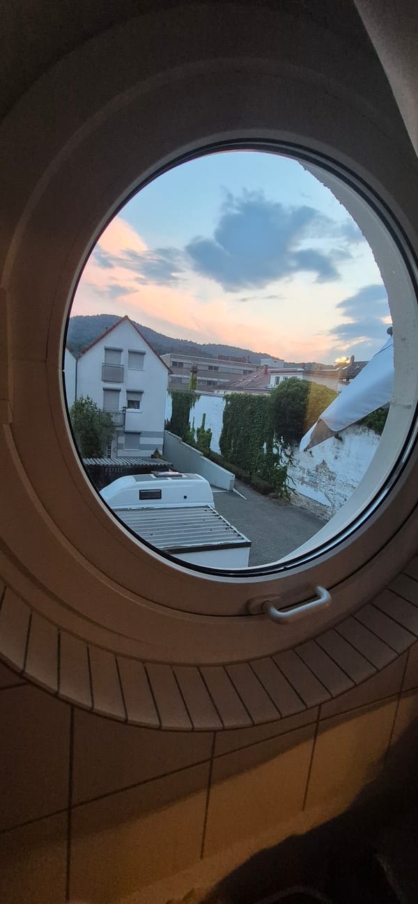 Baden-Baden apartment evening: match on TV, dusk through circular window